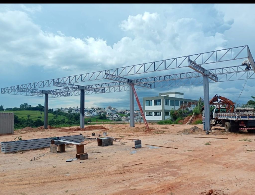 Montagem de estrutura metálica de posto de combustível em andamento com guincho